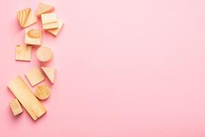 Children's wooden toys on a pink background concept zero west. Frame from developing cubes. Copy space. Top view photo