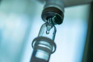 Close up medical intravenous IV drip in hospital background photo