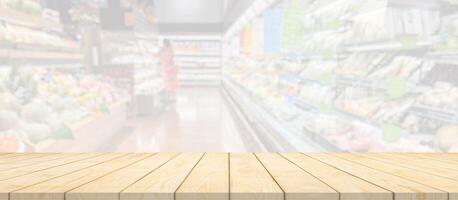 Wood table top with supermarket grocery store blurred background with bokeh light for product display photo