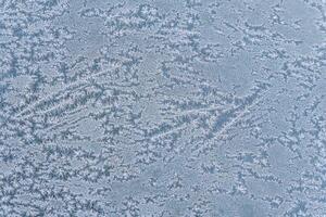 Selective focus. First frost on a frozen car, late autumn close-up. Beautiful abstract frozen microcosmos pattern. Freezing weather frost action in nature. Winter backdrop. photo