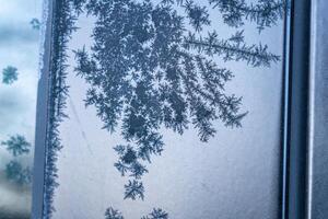 Selective focus. First frost on a frozen black plastic, late autumn close-up. Beautiful abstract frozen microcosmos pattern. Freezing weather frost action in nature. Winter backdrop. photo