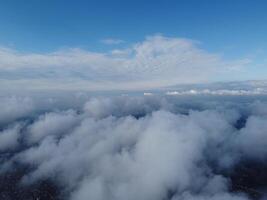 Aerial view. High above thick fog, like beautiful ocean of clouds at sunrise. Sun is rising above the endless sea of clouds until the horizon. Amazing nature landscape. Climate and weather change photo
