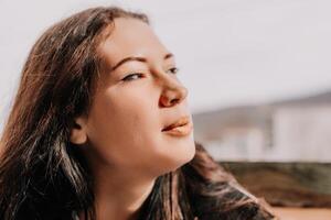 Happy young smiling woman with freckles outdoors portrait. Soft sunny colors. Outdoor close-up portrait of a young brunette woman and looking to the camera, posing against autumn nature background photo