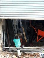 construction workers work to repair a shop. The shop door was half closed, only showing the worker's feet. The door perform a copy space for text ads photo