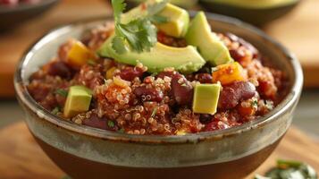 A hearty nutrientdense quinoa and bean chili simmered with avocado oil and topped with fresh avocado chunks for a superfood twist on a classic dish photo
