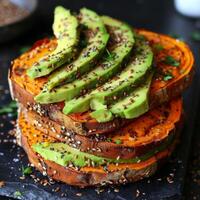 A stack of golden brown sweet potato toasts topped with smashed avocado and a sprinkle of superfood seeds like flax and chia perfect for a quick and nutrientdense meal photo