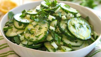 A cooling and refreshing cucumber salad dressed with a simple avocado oil and lemon dressing perfect for a summer barbecue or potluck photo