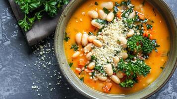 A bowl of creamy white bean and vegetable soup topped with a sprinkle of nutritional yeast for added protein and flavor. White beans are a great source of protein for plantbased diets photo