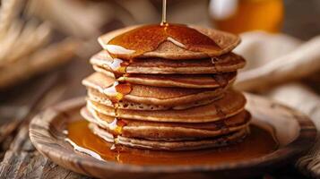 A stack of buckwheat pancakes drizzled with maple syrup photo