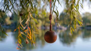 A classic wooden yoyo hovers above a peaceful lake its colorful string entwined with the delicate branches of a weeping willow tree photo