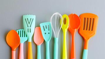 A set of brightlycolored plastic kitchen utensils a spatula s and whisk in a playful retro design photo