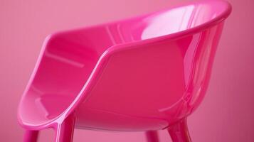 A neon pink plastic chair with a contoured seat and curved backrest perfect for adding a pop of retro color to any room photo