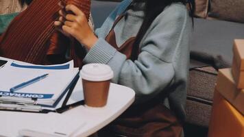 Fashion blogger concept, Young Asian women selling clothes on streaming.Startup small business SME, using smartphone or tablet taking receive and checking in home office video