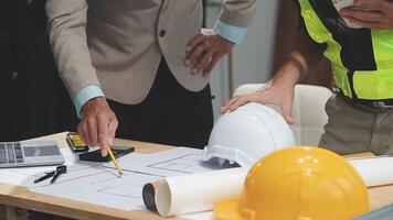 Teamwork men in construction site, Two civil engineer or professional foreman in safety helmet hard hat using blueprint in digital tablet working while standing at industrial factory, teamwork concept video