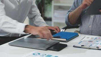 Diverse managers traders analysts discussing financial growth market at desk with laptop with graphs on screen using tablet device. Investors brokers analysing indexes online cryptocurrency stock. video