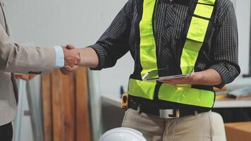 Teamwork men in construction site, Two civil engineer or professional foreman in safety helmet hard hat using blueprint in digital tablet working while standing at industrial factory, teamwork concept video