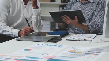 Diverse managers traders analysts discussing financial growth market at desk with laptop with graphs on screen using tablet device. Investors brokers analysing indexes online cryptocurrency stock. video