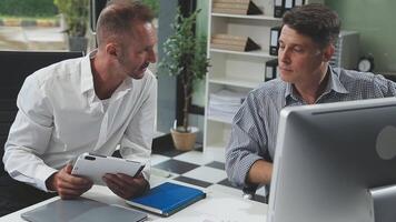 Diverse managers traders analysts discussing financial growth market at desk with laptop with graphs on screen using tablet device. Investors brokers analysing indexes online cryptocurrency stock. video