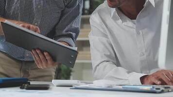 Diverse managers traders analysts discussing financial growth market at desk with laptop with graphs on screen using tablet device. Investors brokers analysing indexes online cryptocurrency stock. video