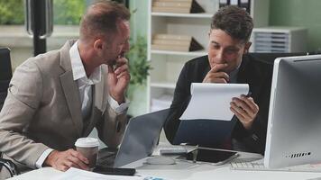 Diverse managers traders analysts discussing financial growth market at desk with laptop with graphs on screen using tablet device. Investors brokers analysing indexes online cryptocurrency stock. video
