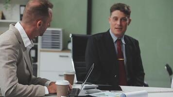 Diverse managers traders analysts discussing financial growth market at desk with laptop with graphs on screen using tablet device. Investors brokers analysing indexes online cryptocurrency stock. video