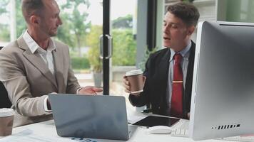 Diverse managers traders analysts discussing financial growth market at desk with laptop with graphs on screen using tablet device. Investors brokers analysing indexes online cryptocurrency stock. video