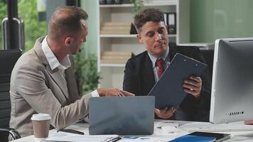 Diverse managers traders analysts discussing financial growth market at desk with laptop with graphs on screen using tablet device. Investors brokers analysing indexes online cryptocurrency stock. video