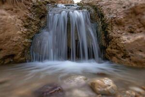 A Waterfall Flowing Down a Rocky Canyon Background photo