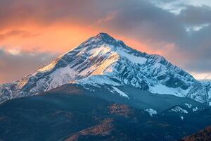 Mountain Peak with Snow Covered Trees and Clouds Background photo