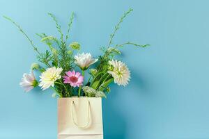 a bouquet of flowers is in a paper bag on a blue background photo