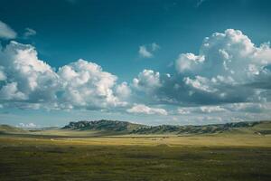 Large open field with grass and hills under a cloudy sky background photo