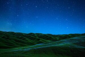 A Green Hill with Grass and Stars Background photo
