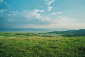 Grassy field with hills and mountains in the background photo