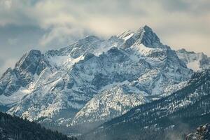 a snowy mountain range with a lake in the foreground background photo