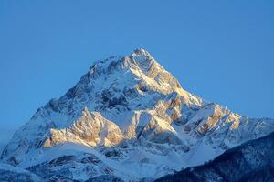 a mountain peak is shown in the blue sky background photo