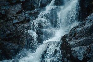 a man standing on a rock next to a waterfall background photo