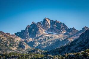 A Mountain Range with a Blue Sky and Trees Background photo