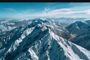 a mountain range with snow on top and blue sky background photo