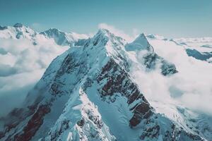 a mountain range is covered in snow and clouds background photo