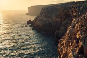 a view of the ocean and cliffs at sunset with background photo