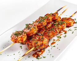 a plate of shrimp skewers with sauce and garnish photo