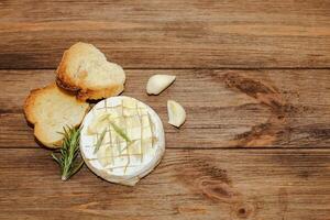 White baguette cut into pieces with olive oil and Camembert cheese on the table. photo