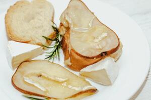 Camembert cheese with olive oil, rosemary and baked pear. photo