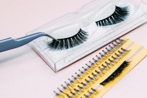 Artificial false fluffy eyelashes with tweezers. photo