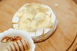 White baguette with olive oil and baked Camembert cheese on the table photo