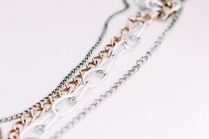Gold and silver jewelry chains of different diameters on a white background. photo