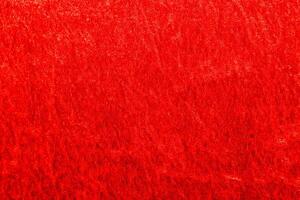 Texture of red velor corduroy fabric with folds photo