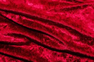 Texture of red velor corduroy fabric with folds photo