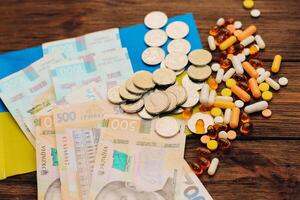 Ukrainian hryvnias with flag of Ukraine with pills and vitamins, healthcare concept photo