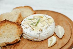 White baguette cut into pieces with olive oil and Camembert cheese on the table. photo